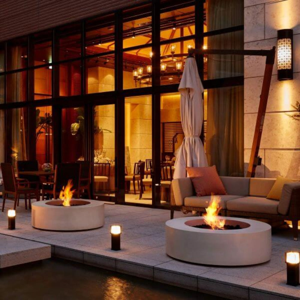 A low fire table and radiant heater bringing warmth to an outdoor lounge after sunset